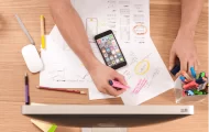 graphic of a person in front of a laptop buried in papers, trying to get organised