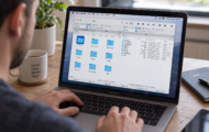 Person using a laptop with a file management application open on the screen at a desk.